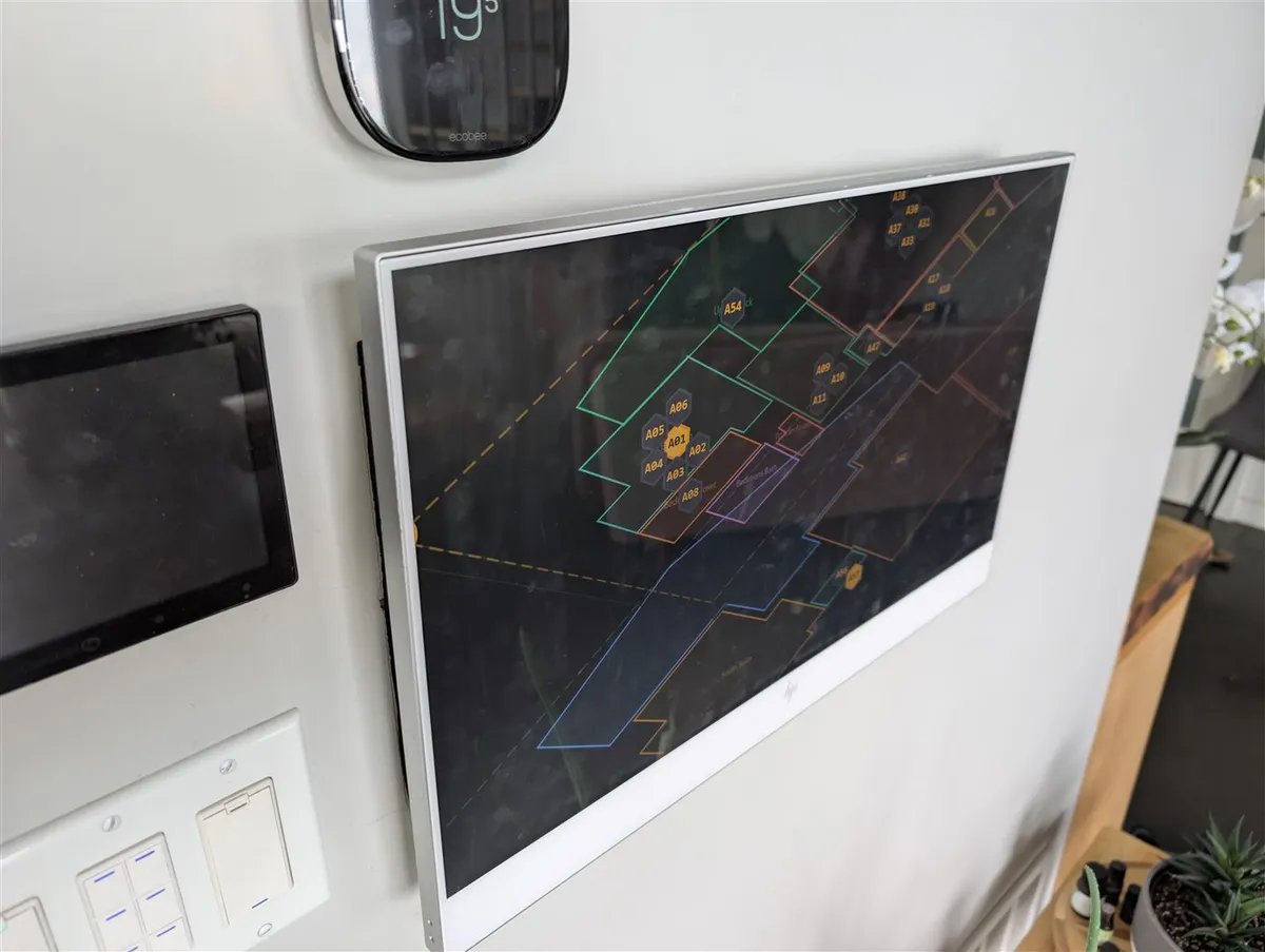 PadSpan live on a wall-mounted panel in the great room, showing the multi-floor map with tracked devices